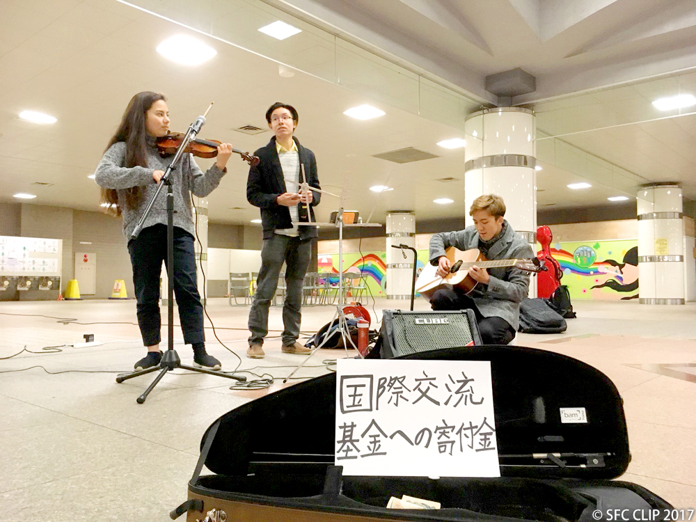 Three students from different school years raising funds through their street performance