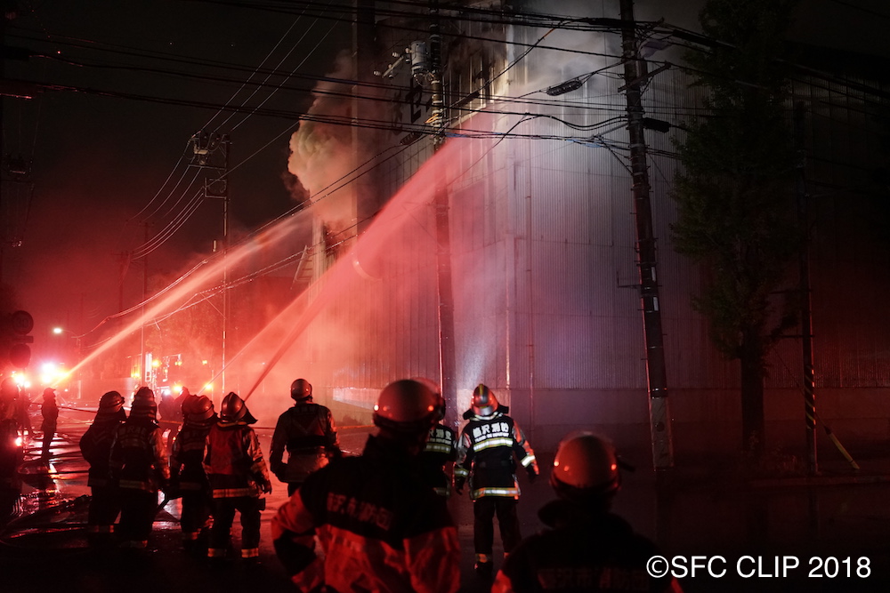 22:00ごろの様子。炎は収まったが、施設の外壁は損傷し、あたりは煙が立ち込めていた。